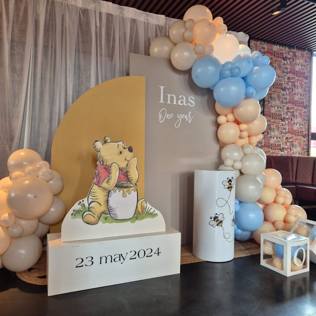 Backfrop de ballons pastel pour décoration anniversaire bébé Winnie l'Ourson.