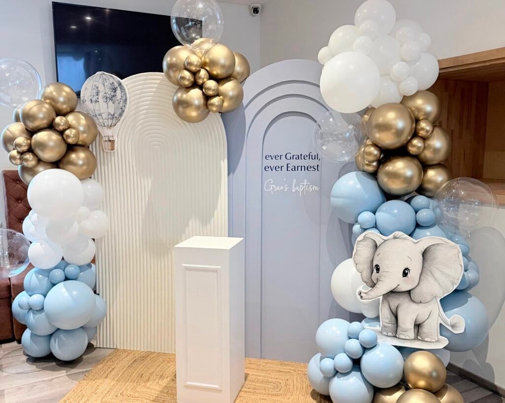 Accueil 11 Décoration baby shower avec Backdrop de ballons blancs, bleus, or et décor d'éléphant pour une fête enfantine.